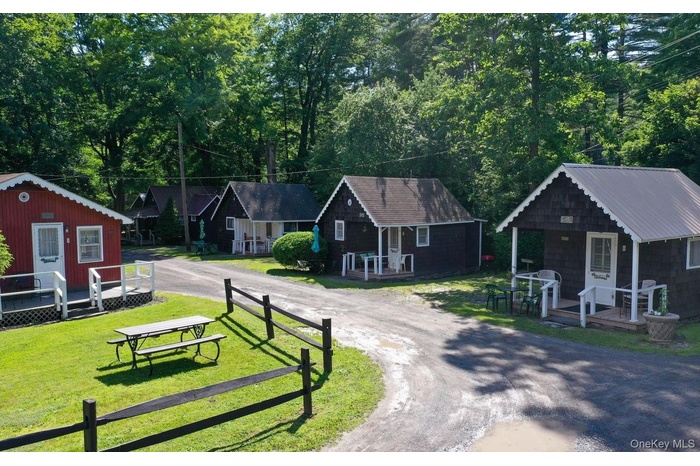 Surrounding community with driveway, a yard, and view of wooded area