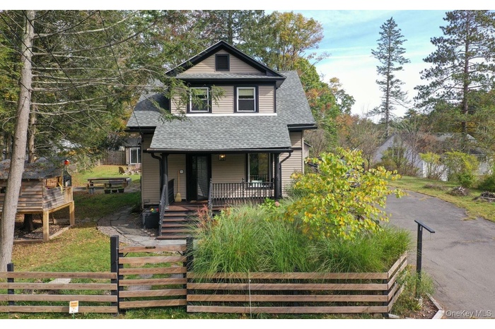 View of front of house with covered porch and roof with shingles