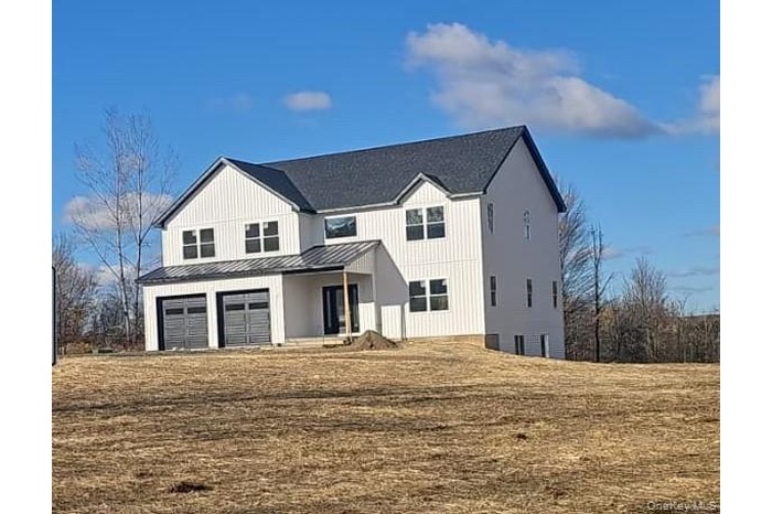 Modern farmhouse featuring a porch, a standing seam roof, a metal roof, and a front yard