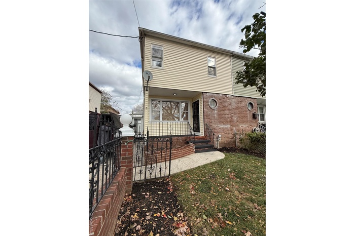 View of front of house with a porch and brick siding