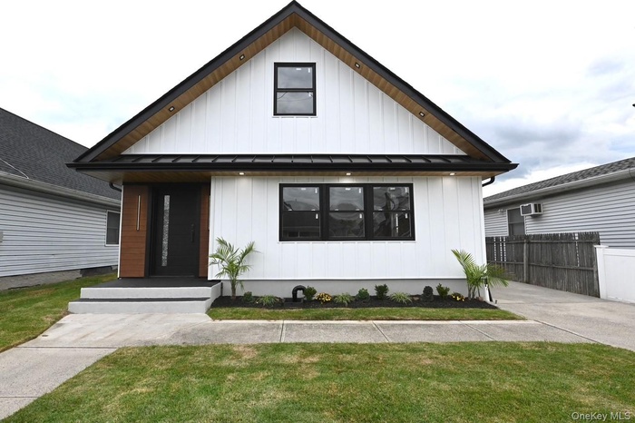 Modern farmhouse with a standing seam roof, board and batten siding, and a metal roof