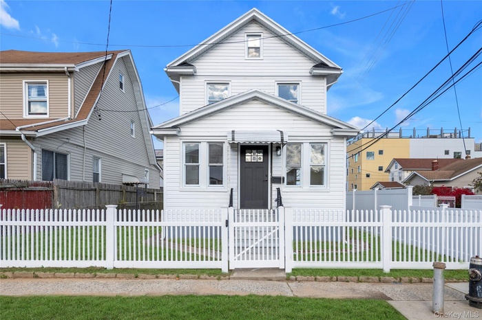 Traditional home featuring a gate and a fenced front yard