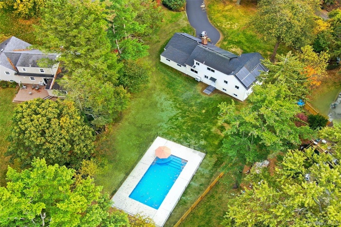 Bird's eye view of a pool area and a tree filled landscape
