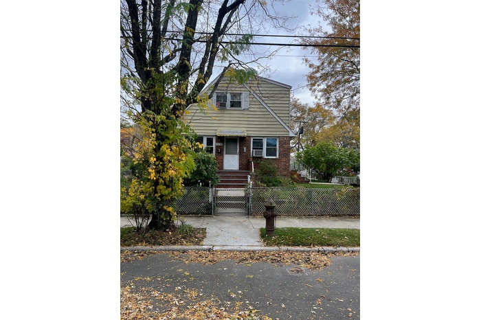 Bungalow-style house with a gate, a fenced front yard, and brick siding