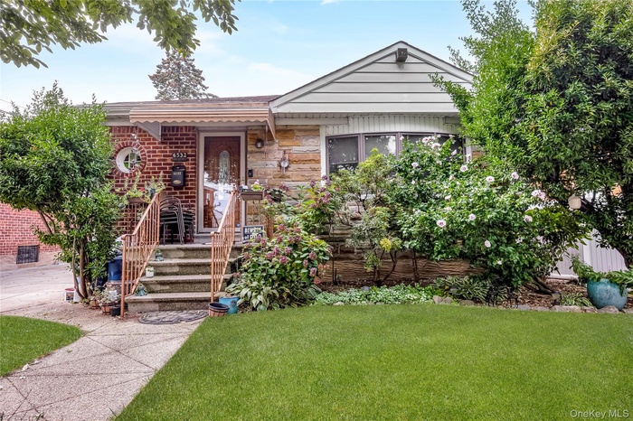 View of front of property featuring a front lawn and brick siding