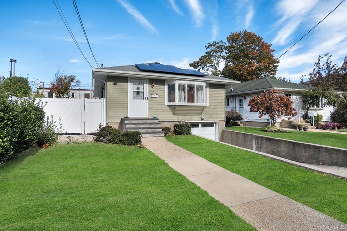 Bungalow featuring roof mounted solar panels and an attached garage