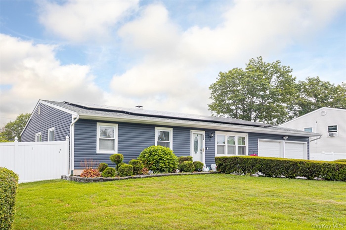 Single story home featuring an attached garage and roof mounted solar panels