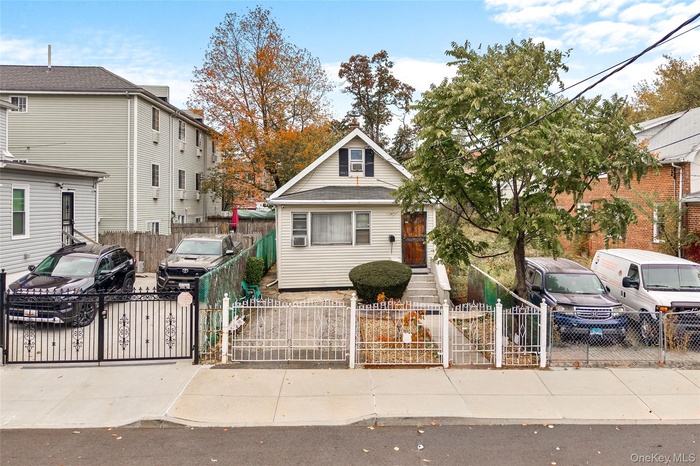 View of front facade with a fenced front yard and a gate