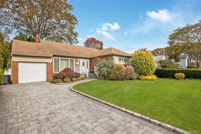 Single story home with a front lawn, decorative driveway, a garage, a chimney, and a shingled roof
