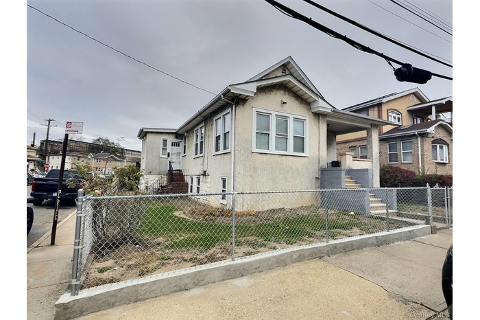 View of property exterior with stucco siding and a fenced front yard