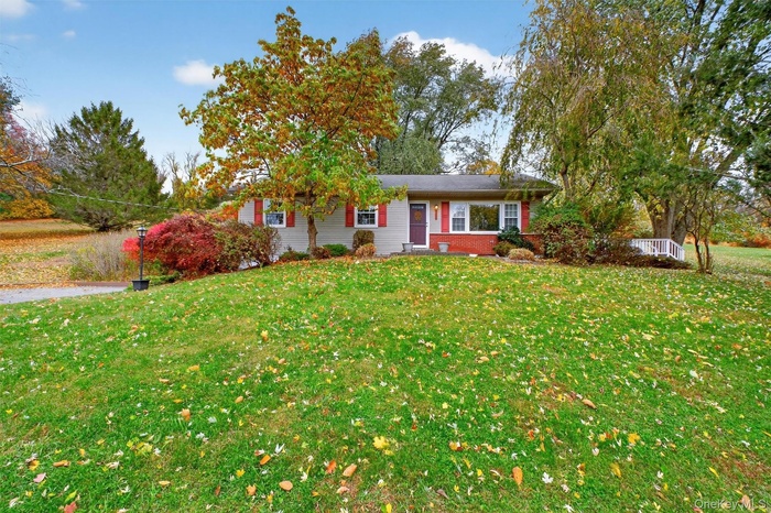 Single story home with a front lawn and brick siding