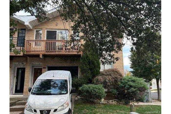 View of front of house with brick siding and a balcony