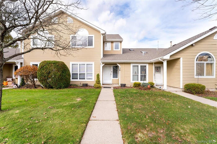 Traditional home featuring a shingled roof and a front lawn