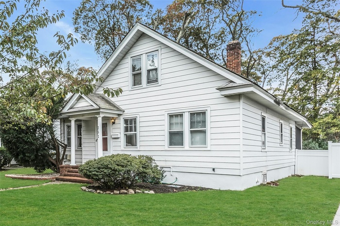 Classic white light filled home with front porch, long driveway and oversized property on tree lined block