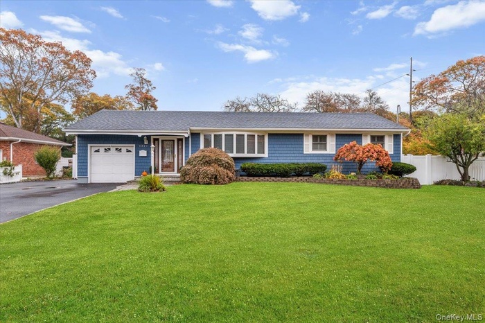 Ranch-style home with driveway, an attached garage, and a shingled roof