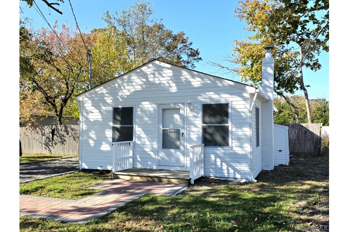 View of front of house featuring a chimney and a deck