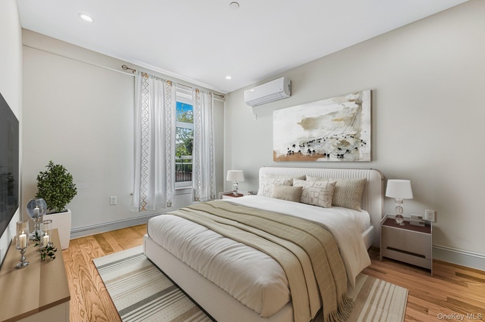 Master Bedroom featuring light wood finished floors, a wall unit AC, and recessed lighting