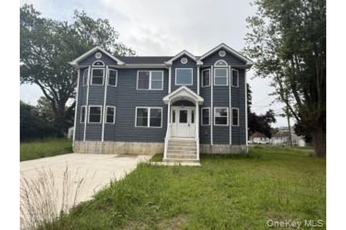 View of front of home featuring a front lawn and concrete driveway