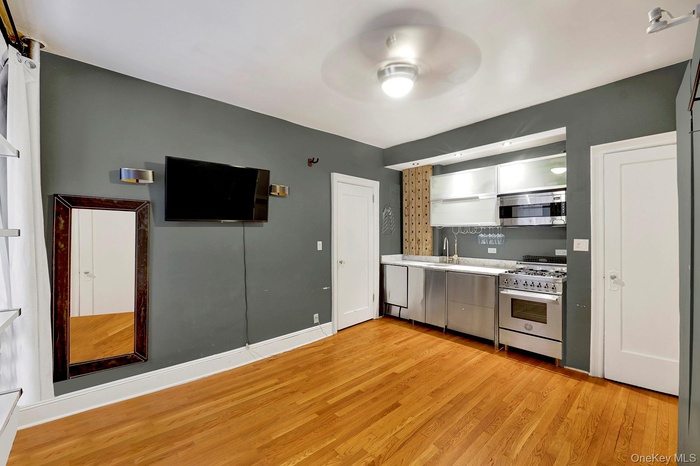 Kitchen featuring light countertops, appliances with stainless steel finishes, light wood finished floors, and a ceiling fan