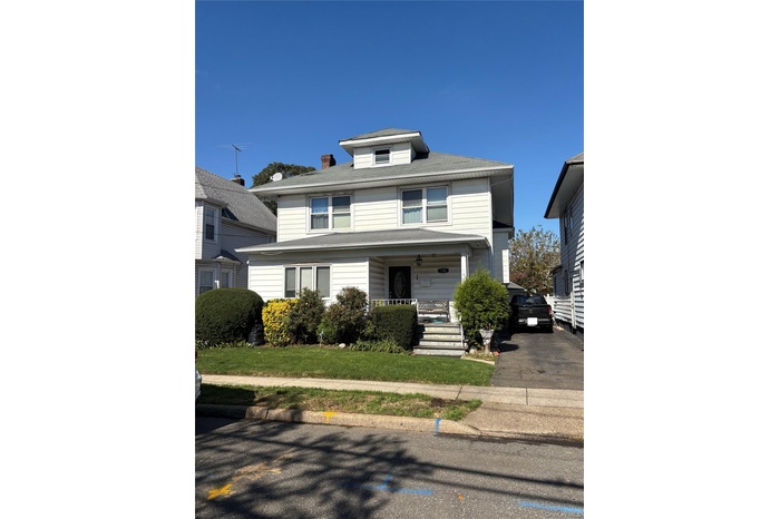 Traditional style home featuring covered porch and a chimney