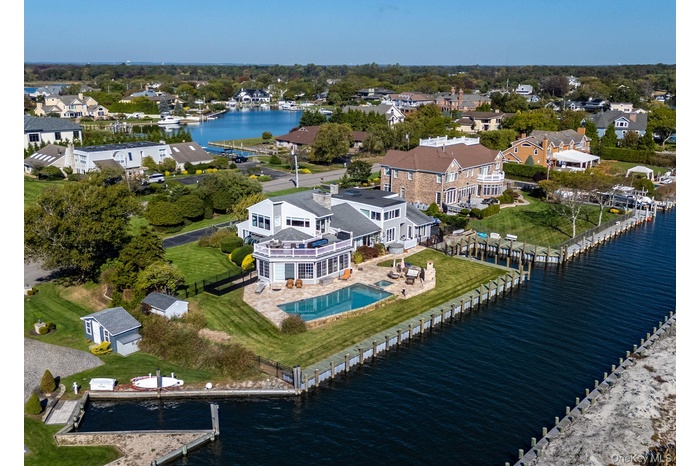 Aerial view of residential area featuring a nearby body of water and a pool