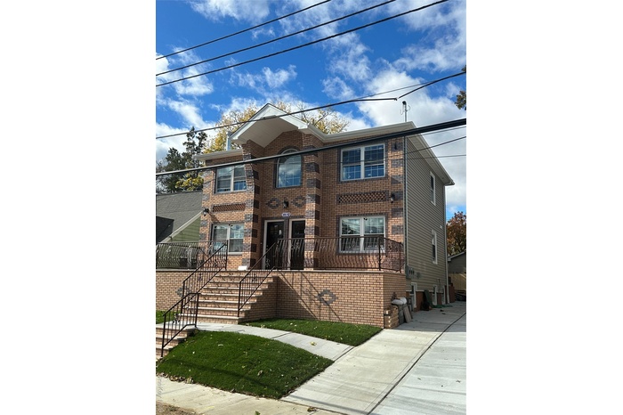 Traditional-style house featuring brick siding and stairway