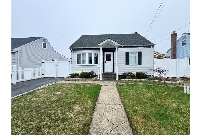 Bungalow-style house with roof with shingles, fence, a front lawn, and a gate