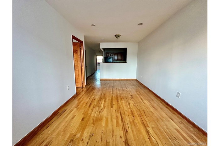 Empty room with light wood-type flooring and baseboards