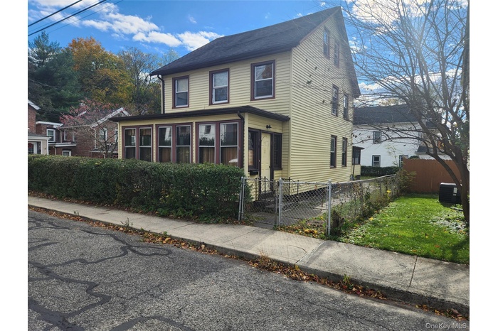 View of front of property featuring a fenced front yard and a gate