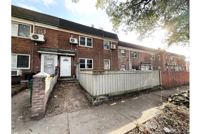View of front facade featuring a fenced front yard and brick siding