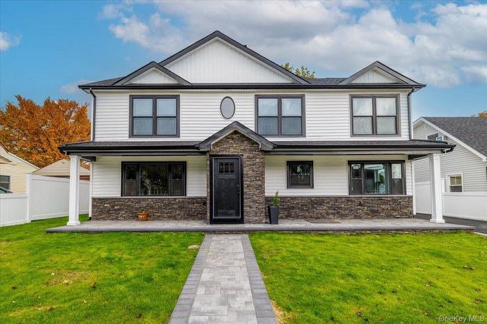 View of front of house featuring stone siding and covered porch