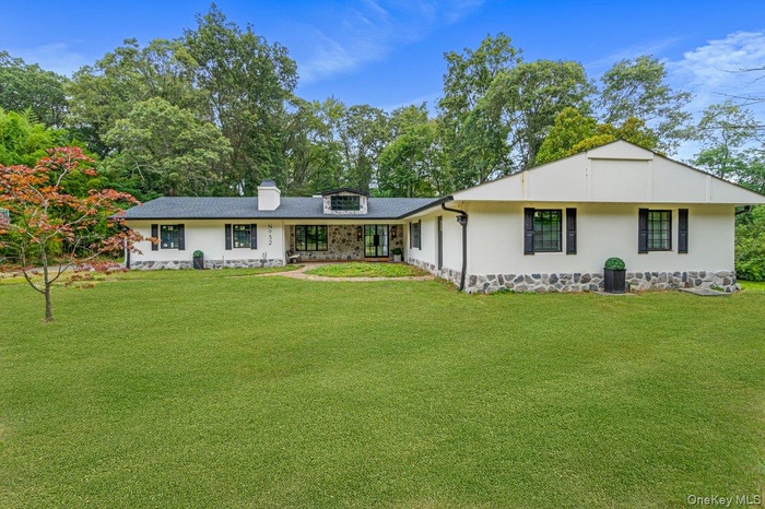 View of front facade featuring a front yard and a chimney