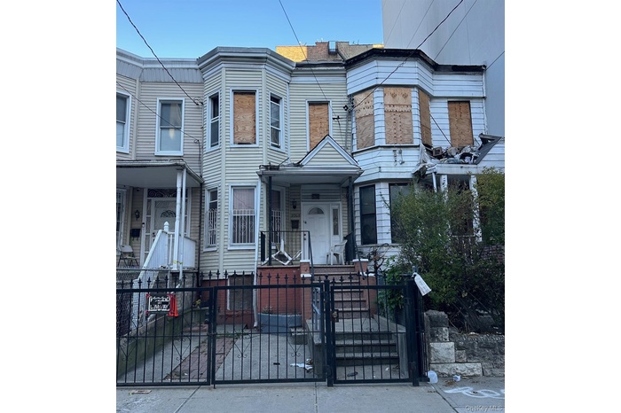 View of front of house featuring a gate, a fenced front yard, and a porch