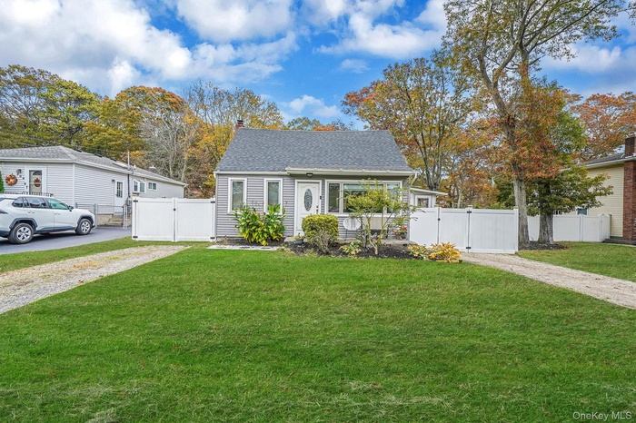 View of front facade featuring a gate, a chimney, and a shingled roof