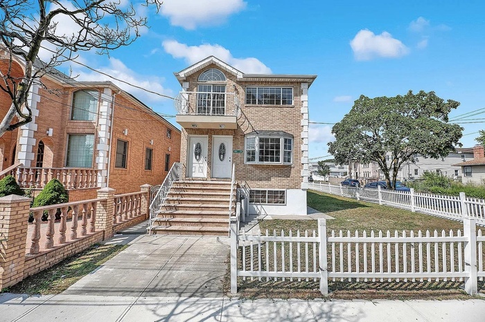 View of front of property featuring brick siding and a fenced front yard