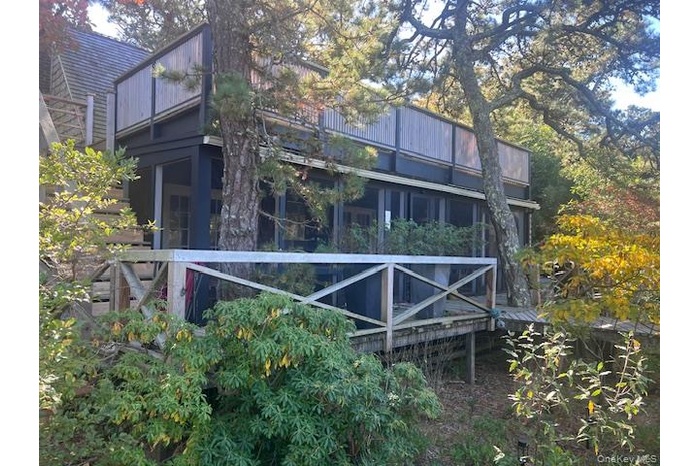 Back of property with a sunroom and a wooden deck