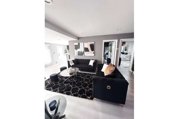 Living room featuring wood finished floors and beam ceiling