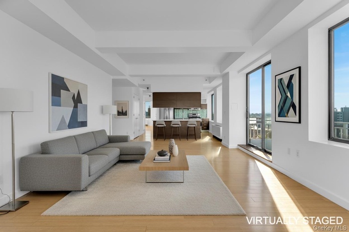 Living area featuring light wood-type flooring, beamed ceiling, and radiator heating unit