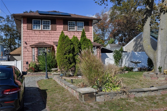 View of front of home with solar panels and roof with shingles