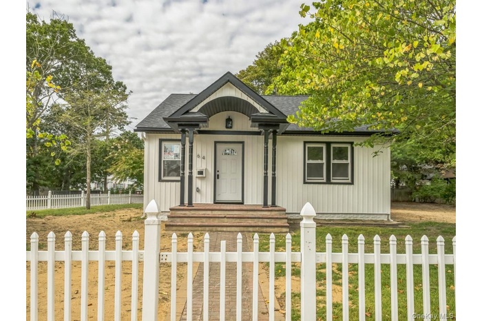 View of front of home featuring a fenced front yard and a shingled roof