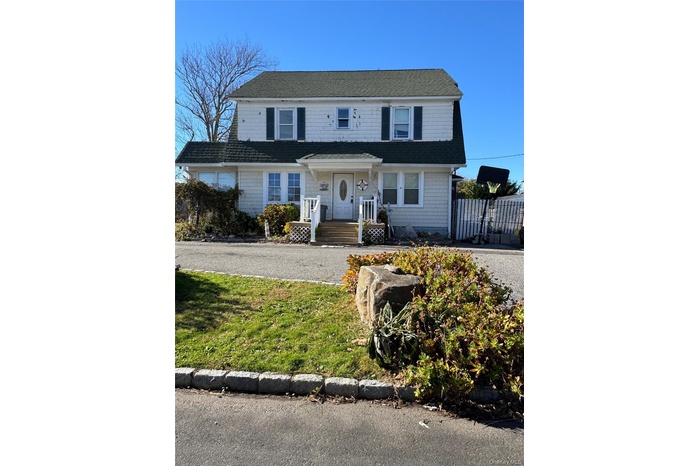 View of front of home with a porch and a front lawn