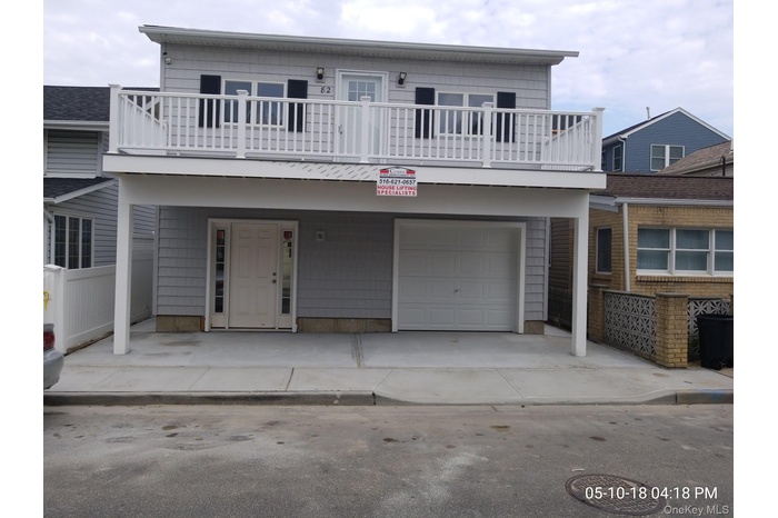 View of front of property with an attached garage, a balcony, and concrete driveway