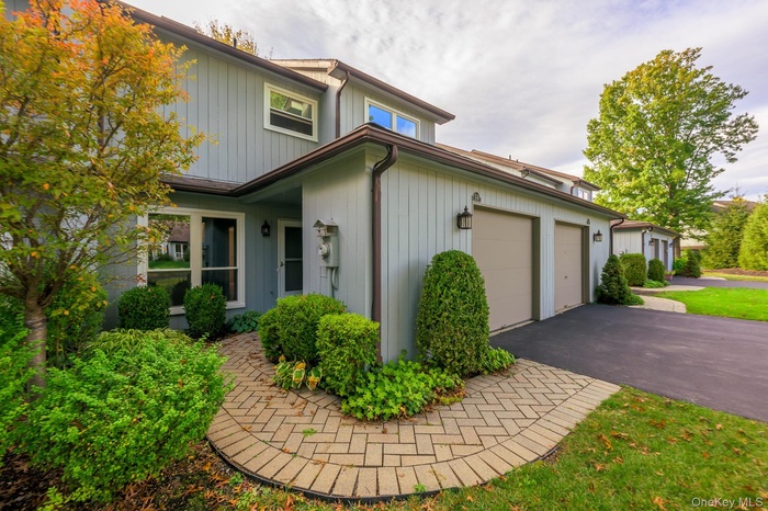 View of front facade featuring asphalt driveway and a garage