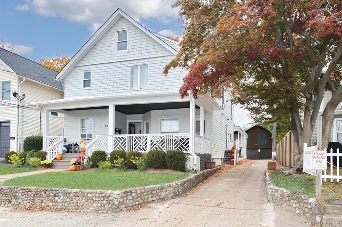 Traditional style home featuring a porch and a front yard