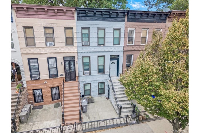 View of front of property featuring stairs, a fenced front yard, and a gate