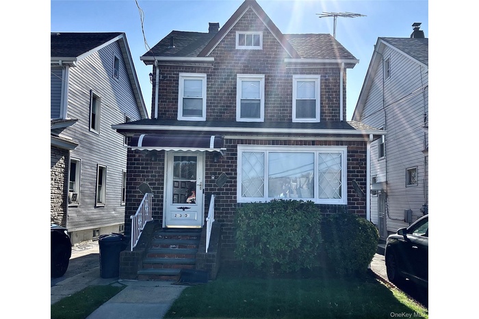 Traditional home featuring brick siding and roof with shingles