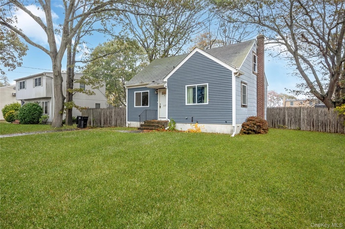 View of front of house featuring a chimney and a shingled roof