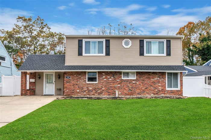Traditional home featuring brick siding, a porch, and a shingled roof