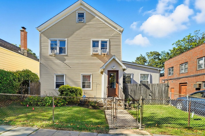 Traditional-style house featuring a gate and a fenced front yard