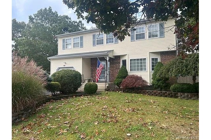 Traditional-style home with a front yard and brick siding